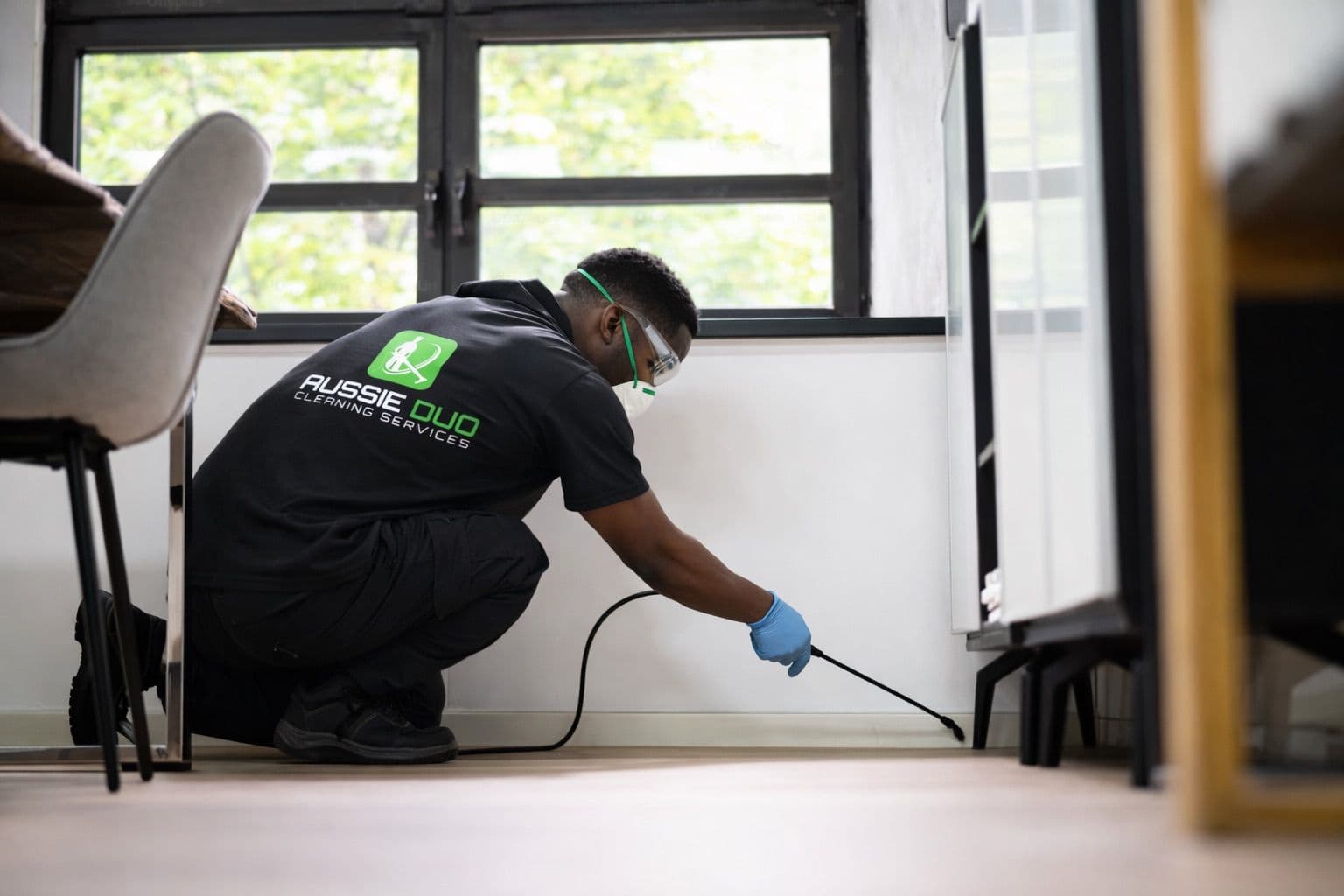 Professional cleaner applying spring chemical on the curtain board as part of a detailed domestic cleaning service.