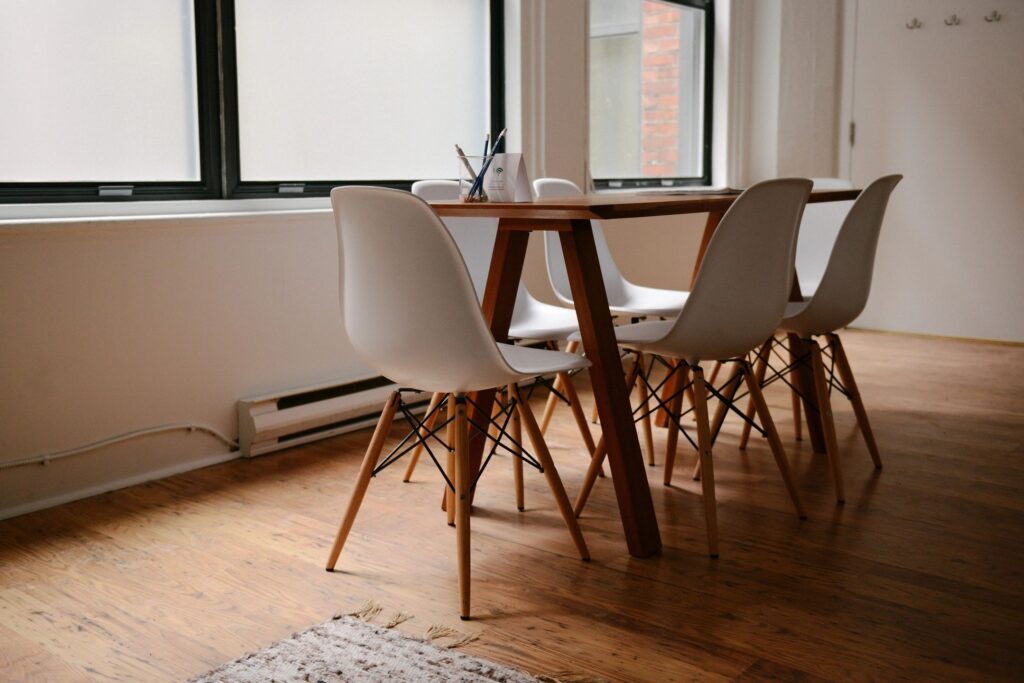 a table with white chairs and a pencil holder